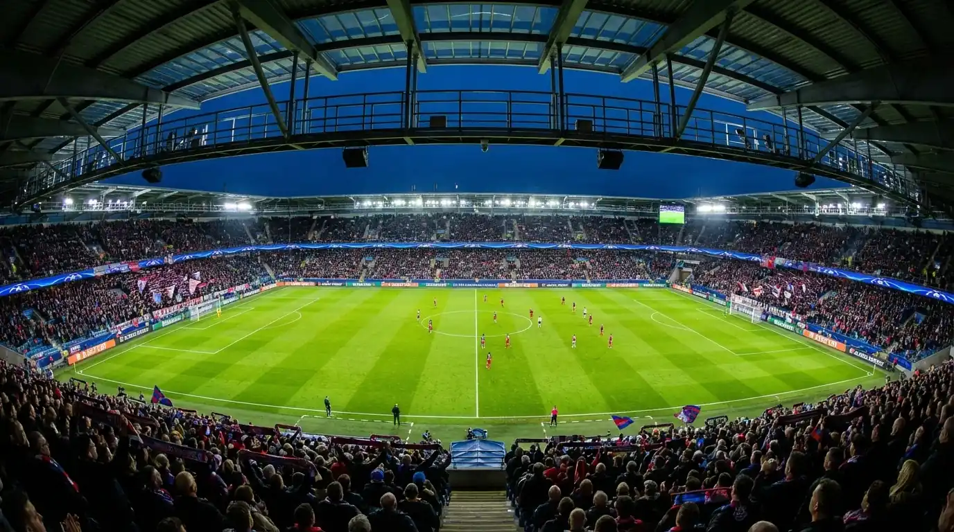 Estadio de fútbol europeo durante un partido nocturno de la Champions League con gradas llenas de aficionados